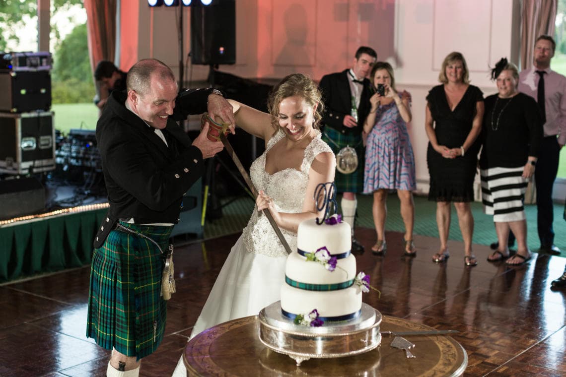 Pavilion newlyweds cut the cake with a sword