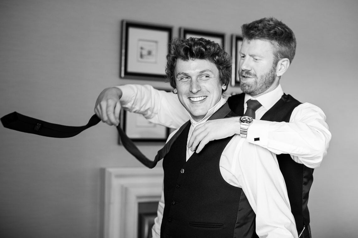 best men putting on a tie