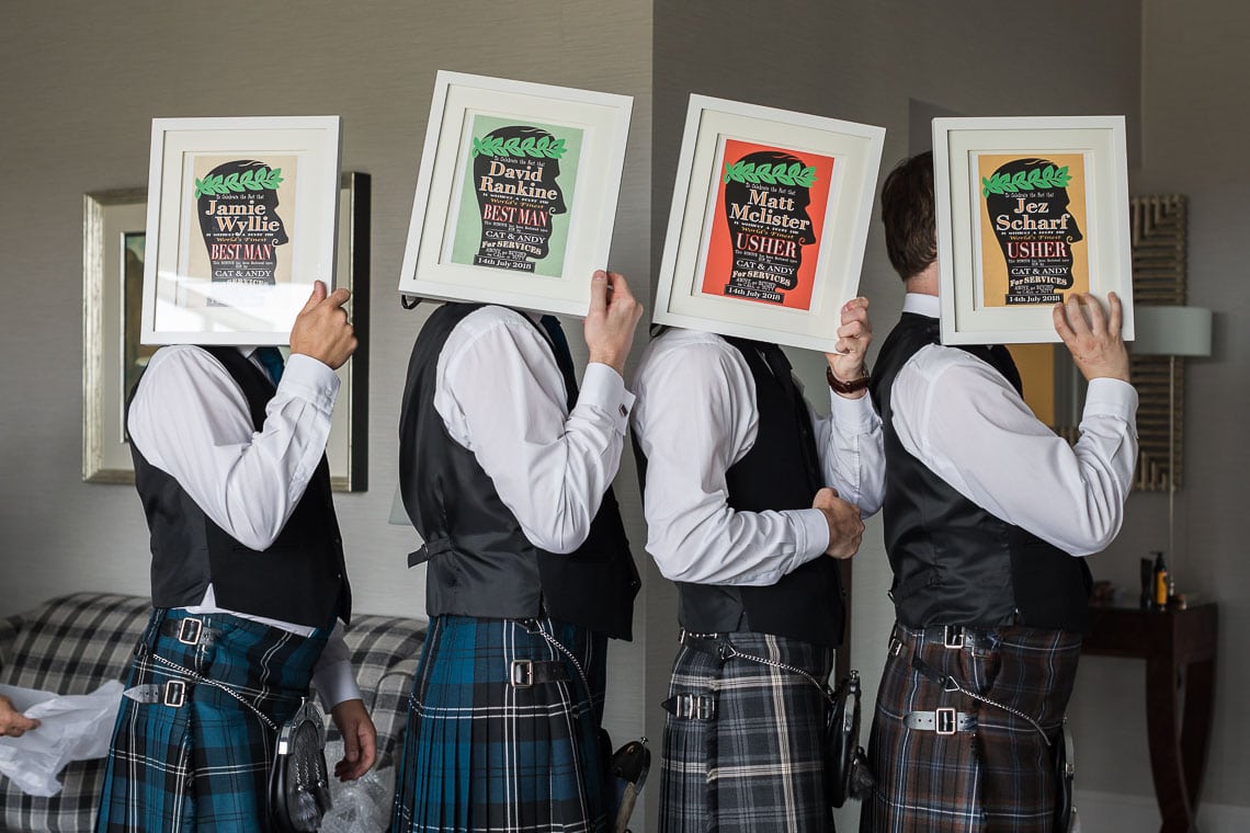 best men holding framed gifts