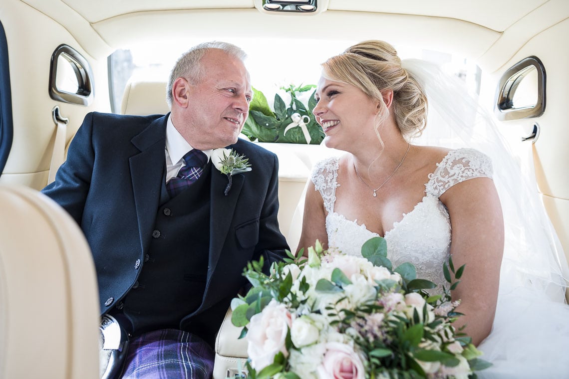 bride smiling at her father in a Bentley