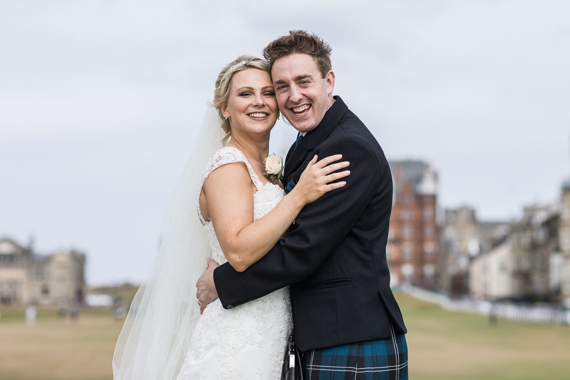 newlyweds embrace on Swilken Bridge