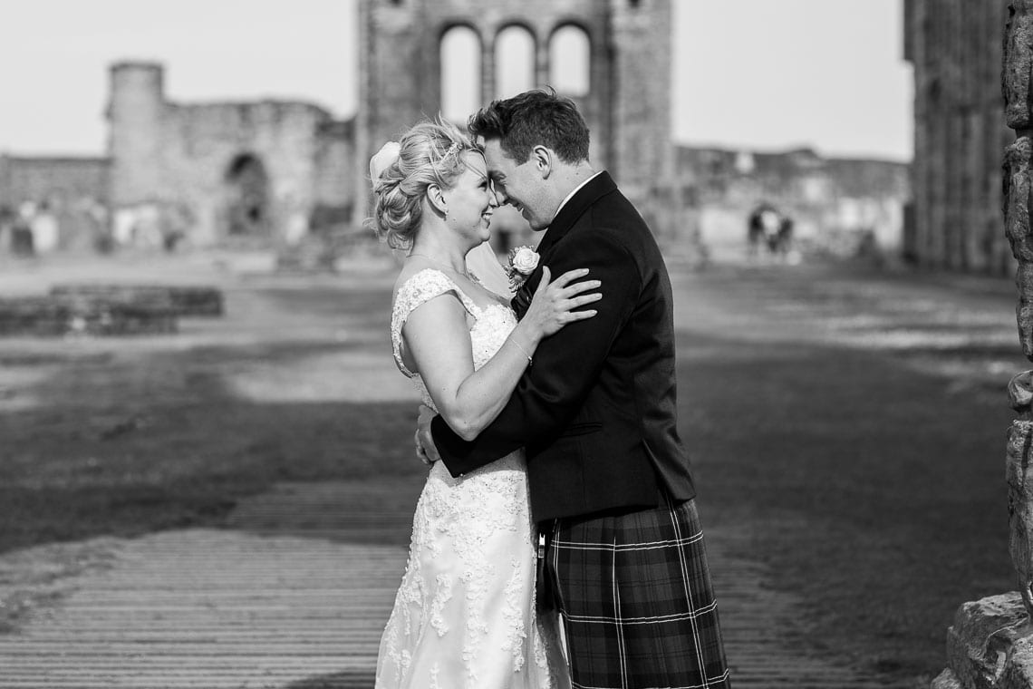 newlyweds embrace under the arch at St Andrew's Cathedral