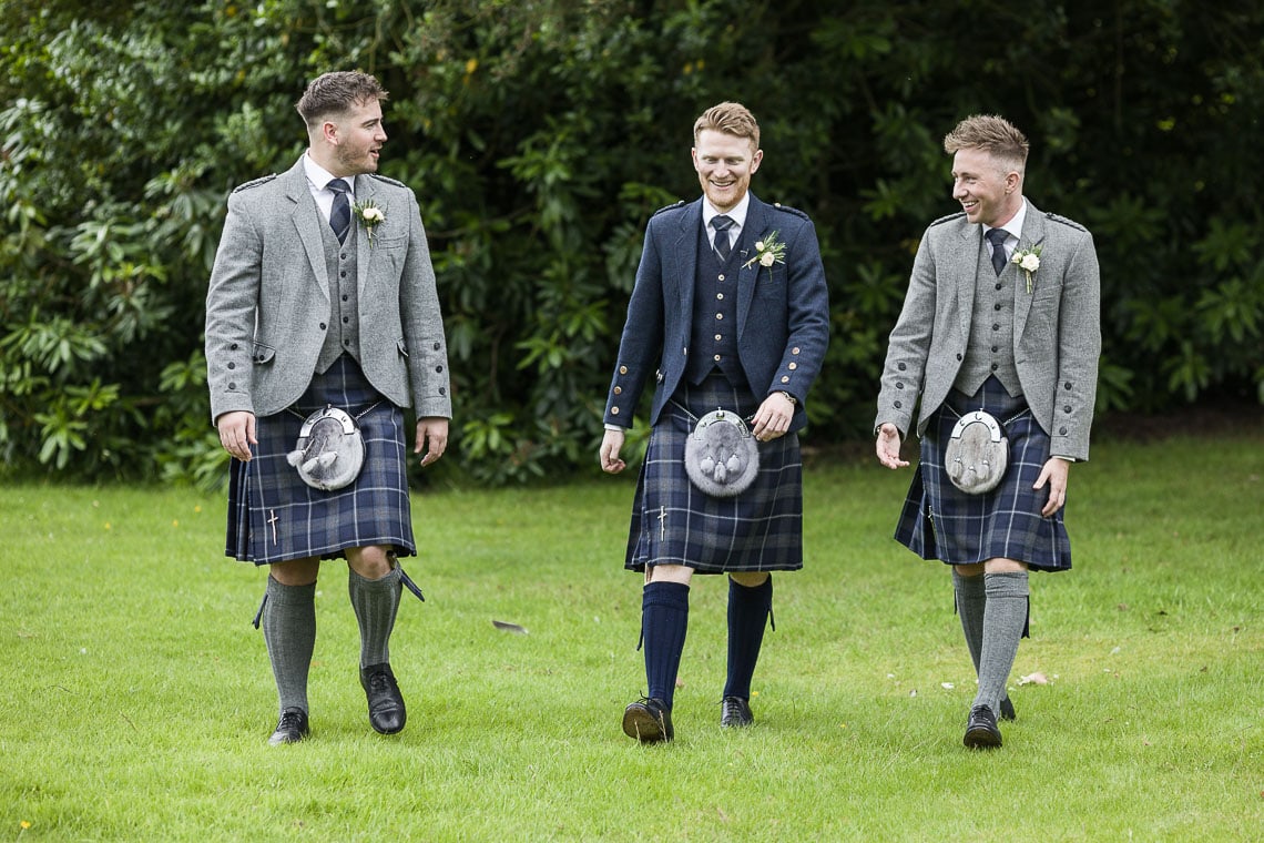groom and best men on the lawn outside the church