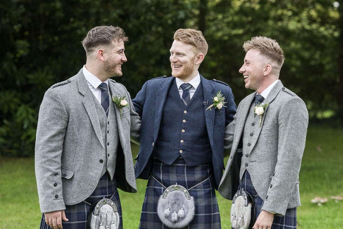 groom and best men on the lawn outside the church