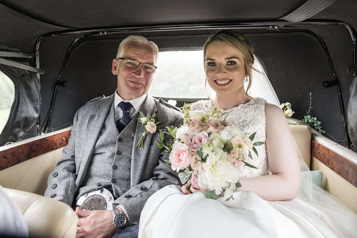 bride and her father sitting inside a Beauford car