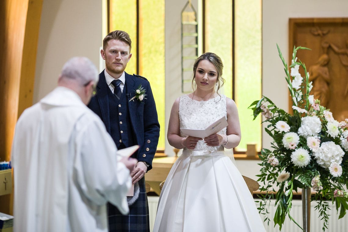 bride and groom listening to Priest