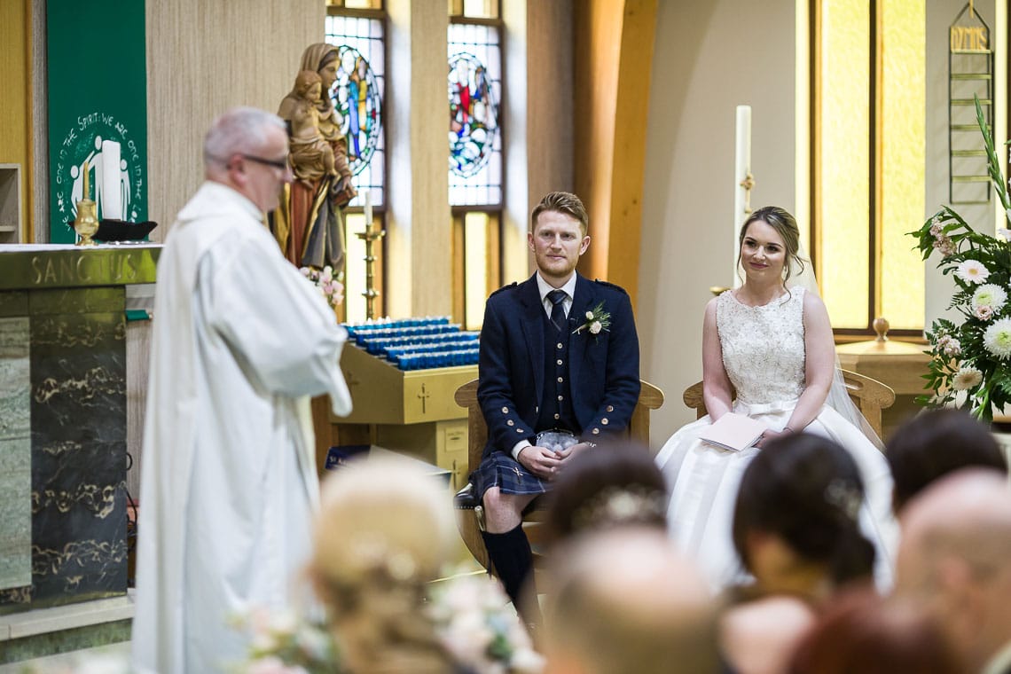 bride and groom listening to Priest