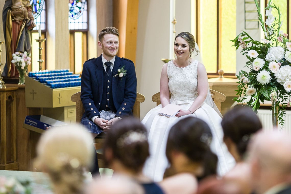 bride and groom listening to Priest