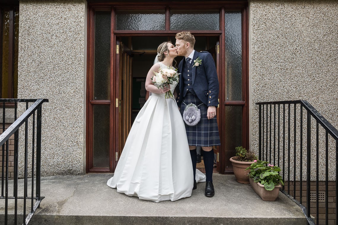 newlyweds kissing as they exit the church