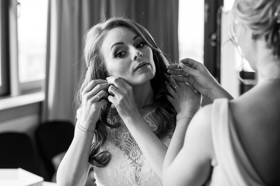 bride putting in her earrings in the Forthview Suite
