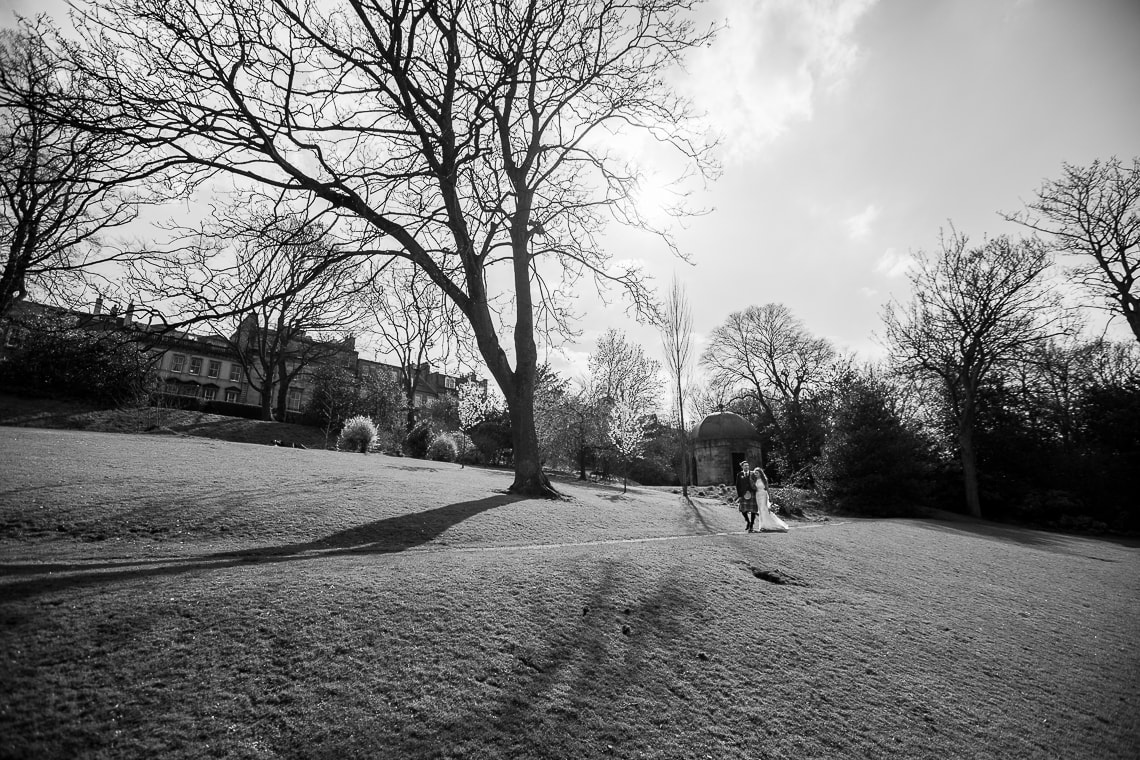 newlyweds walking in Queen Street Gardens view from the side