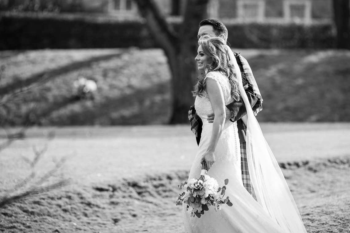 newlyweds walking in Queen Street Gardens view from the side