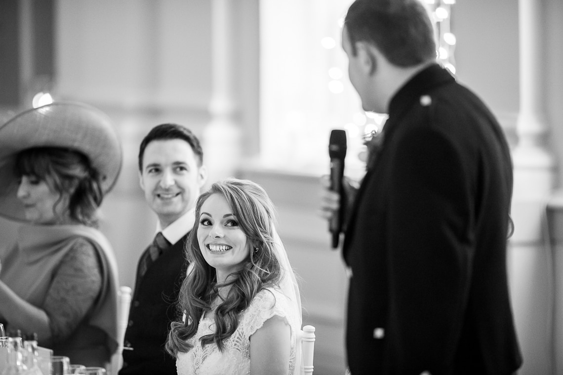 bride smiles during her brother's speech in the King's Hall