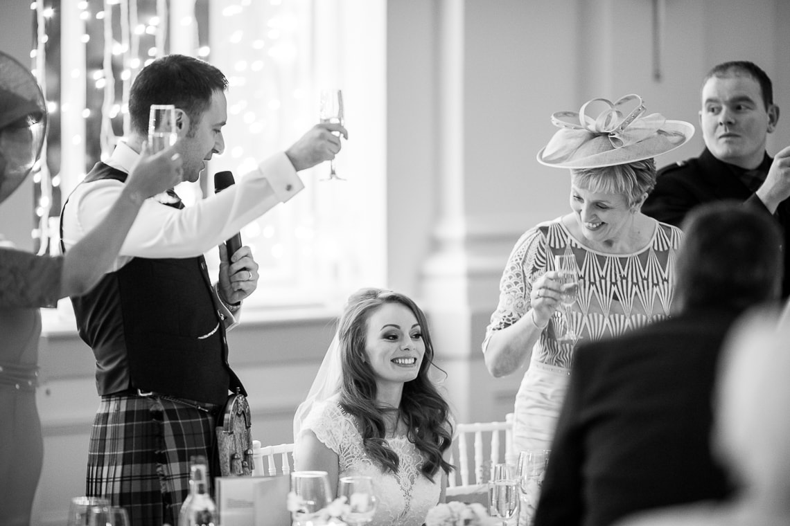 groom raises a toast in the King's Hall