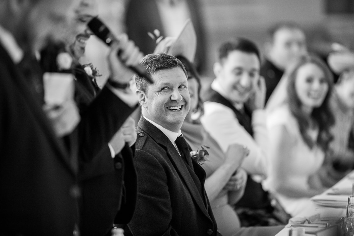 father of the groom laughing during the best men speech in the King's Hall
