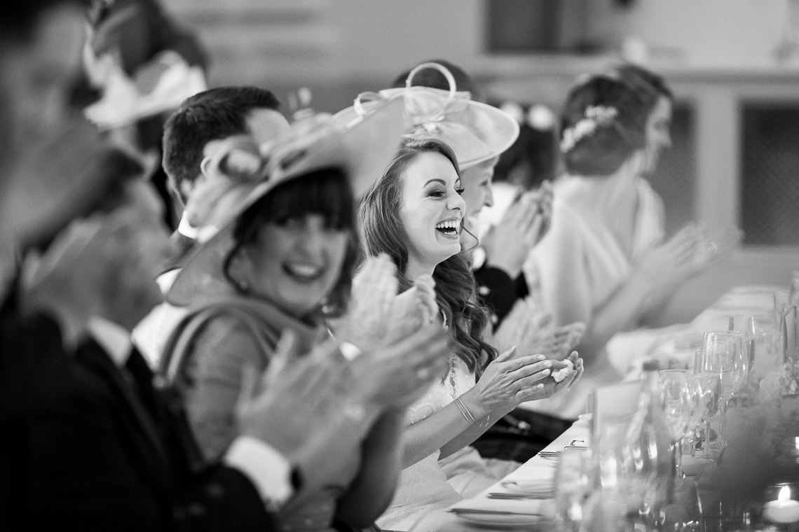 bride laughing during the best men speech in the King's Hall