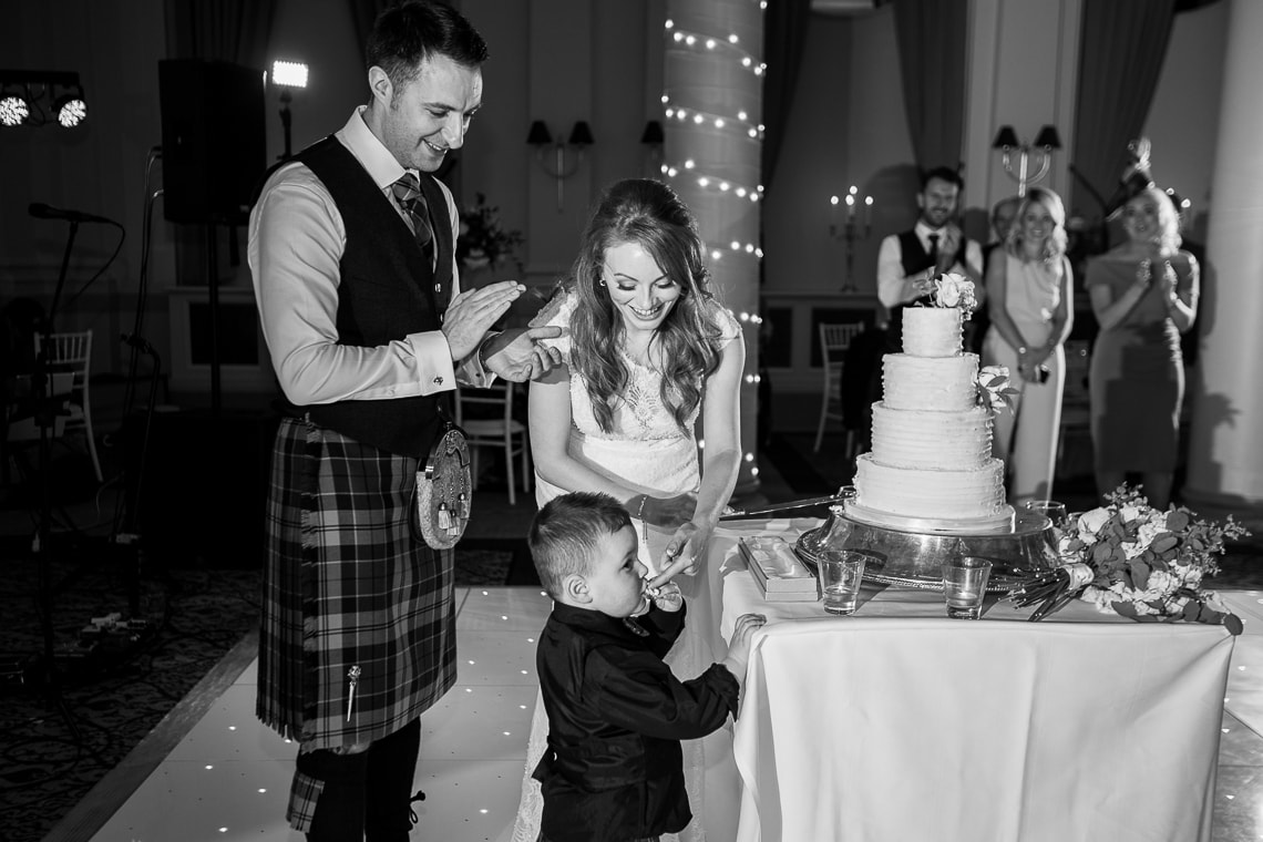 little boy eating a piece of cake in the King's Hall