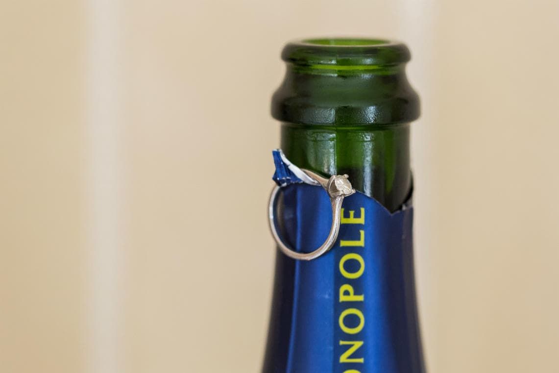 bride's engagement ring on champagne bottle