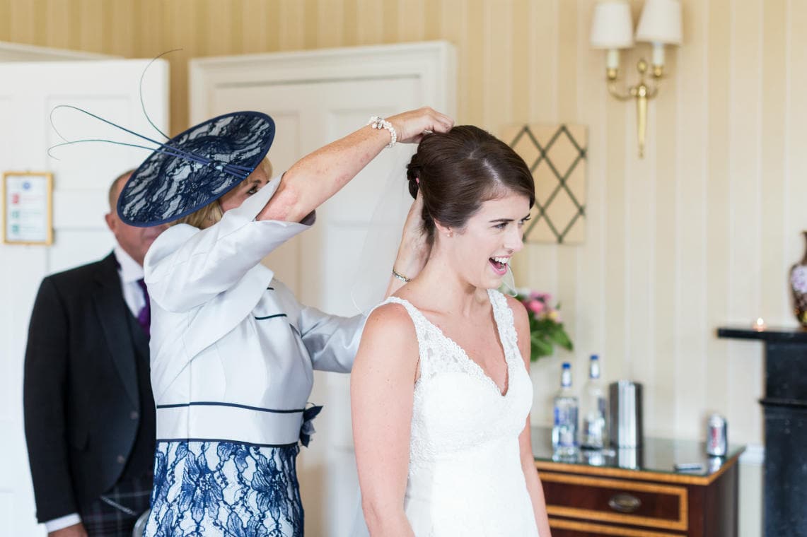 mother of the bride helps fit bridal veil