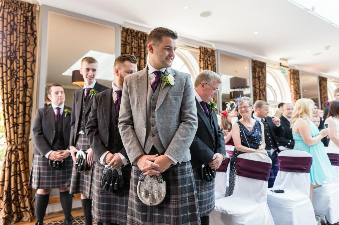 groom watches wedding processional bridesmaids walk up the aisle