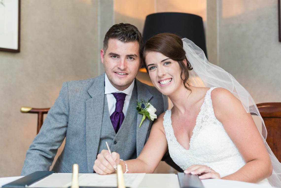 newlyweds smiling after signing the marriage schedule