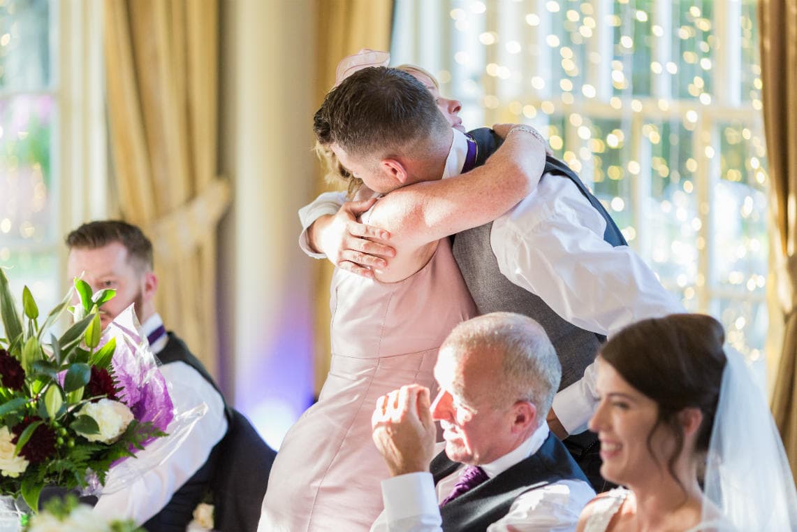 groom hugs mother during speech