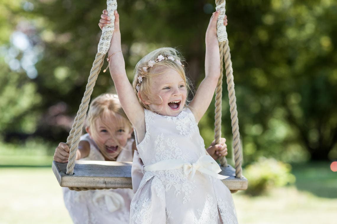 flower girls playing on swing