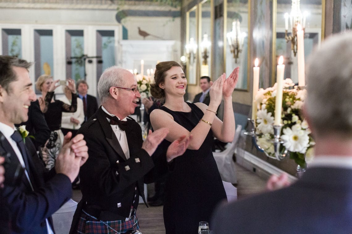 Guests standing and clapping at reception