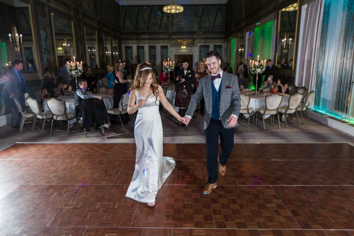 Newlyweds making their way to the dancefloor for their first dance